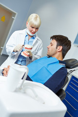 Obraz premium Dentist explaining dental treatment with dentures