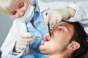 Dentist giving dental treatment to man