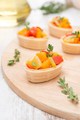 tartlets with roasted vegetables and thyme on a wooden board