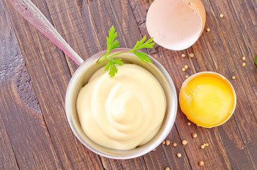 mayonnaise in metal spoon on wooden board