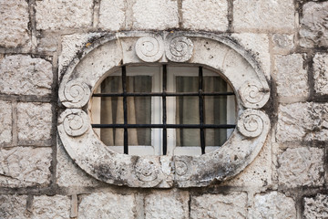 Ancient stone wall with metal window bars