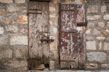 Locked ancient wooden doors in gray stone wall