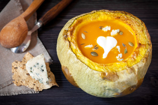 Pumpkin soup in a pumpkin baked with blue cheese camembert
