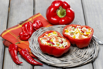 Red pepper stuffed with rice and vegetables on wicker tray.