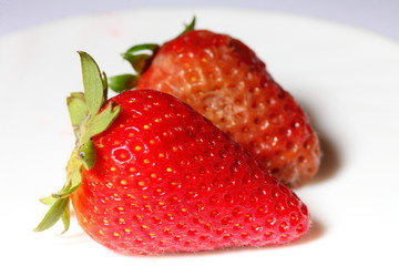 healthy and rotten spoiled bad red strawberries