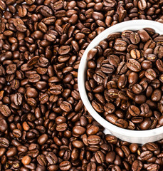 Coffee cup with beans on Coffee background or texture, closeup.