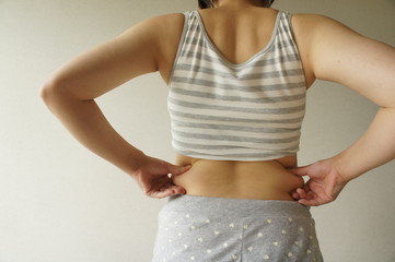 背中をつまむ女性
