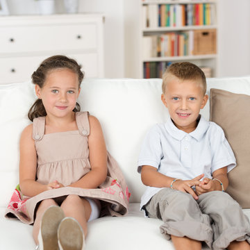 zwei süße kinder sitzen auf dem sofa