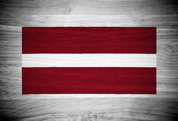 Latvia flag on wood texture