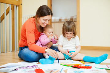 Happy mother with  children plays at home