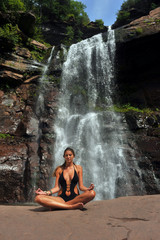 Fototapeta na wymiar Beautiful girl wearing black one- piece swimsuit meditating