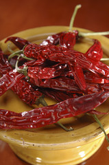 Dried red chili peppers on a ceramic plate