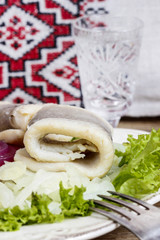 Herring rolls on onion and fresh lettuce. Selective focus