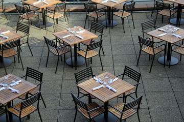 Wood tables and chairs set neatly for lunchtime