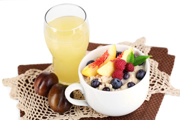 Oatmeal in cup with berries on napkins isolated on white