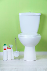 White toilet bowl and cleaner bottle in a bathroom