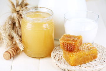 Honey and milk on wooden table close-up