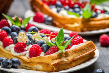 Closeup of waffels with cream and berry fruits