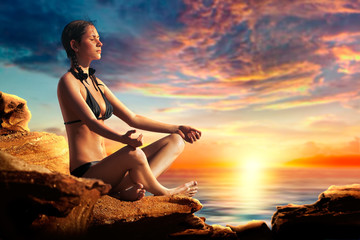 Sexy yoga girl relaxing and meditating on the beach - obrazy, fototapety, plakaty