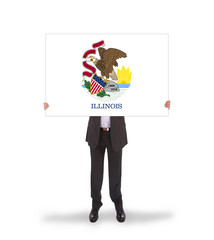 Smiling businessman holding a big card, flag of Illinois