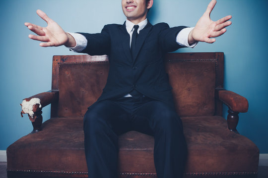 Businessman on sofa is ready for a hug
