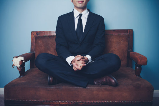 Calm businessman sitting with legs crossed