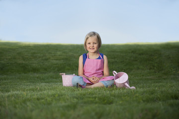 little girl with watering can in the garden