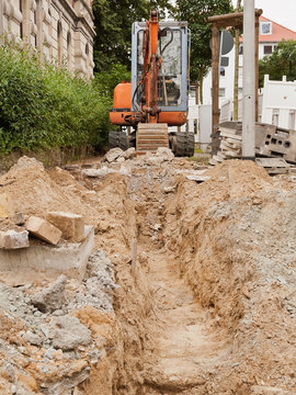 Strassenbau - Ein Minibagger hebt einen kleinen Graben aus