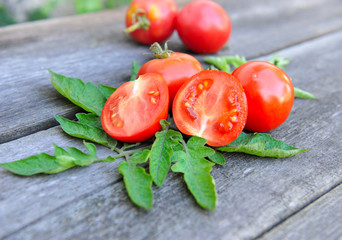 Tomatoes are with leaves on an old wooden table