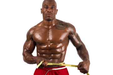 Black bodybuilder taking measurements of his big muscles