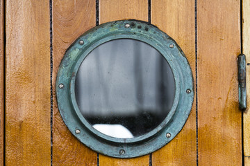 Boat porthole close up wood planks