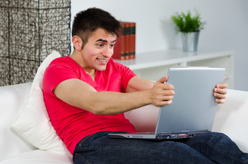 wütender junger mann mit laptop
