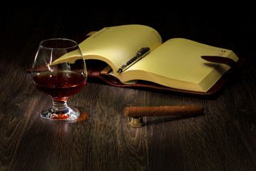 Cognac, cigar and an old book nearby