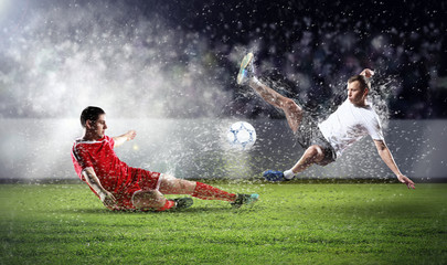 two football players striking the ball