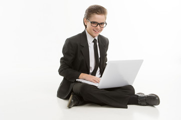 Little businessman with laptop. Cheerful little boy in formalwea