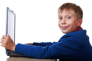 Adorable blond boy working at a notebook smiling