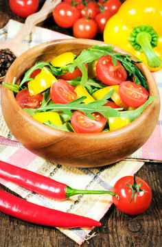 salad with cherry tomatoes and rugula in a wooden bowl