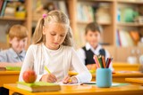 Little schoolgirl sitting behind school desk