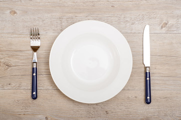 Blaue Messer und Gabel und weisser Teller