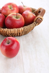 close up of basket with apples on wooden table