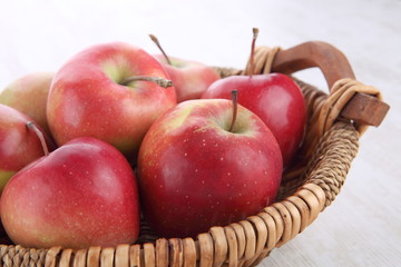 close up of basket with apples on wooden table