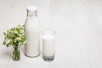 milk bottle and glass on wooden background