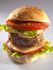 burger in homemade bread with cheese, onion, tomato and lettuce