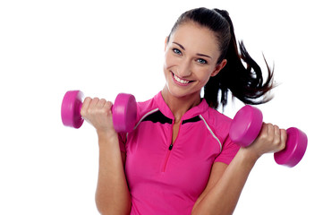 Happy fitness woman lifting dumbbells