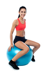 Woman in gym exercising with pilates ball