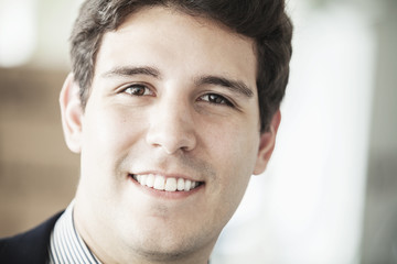Obraz premium Portrait of young smiling businessman looking at camera, head and shoulders