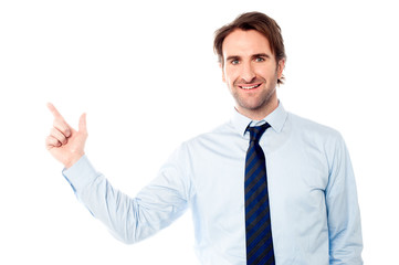 Young male executive pointing away