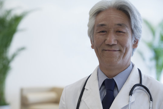 Portrait Of Mature Doctor Looking At Camera And Smiling