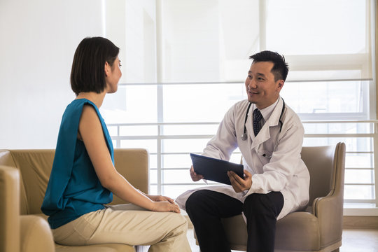 Doctor Sitting Down And Consulting Patient In The Hospital