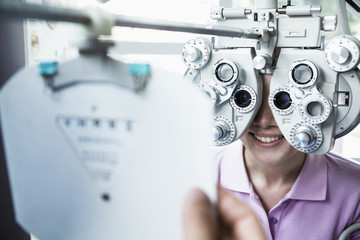 Close-up of optometrist doing an eye exam on young woman - obrazy, fototapety, plakaty